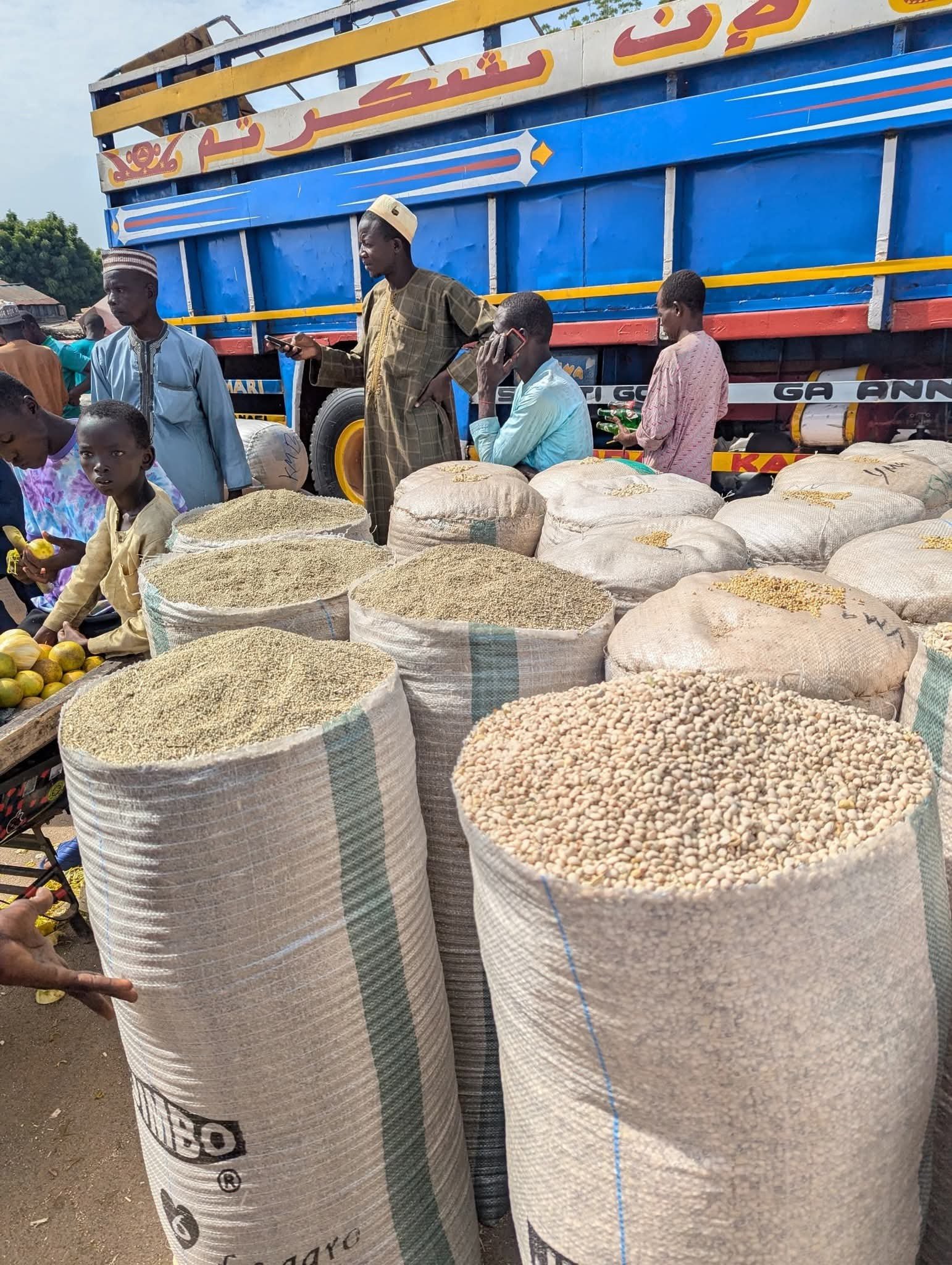 Sacks of agricultural commodities beside a haulage truck at a produce market